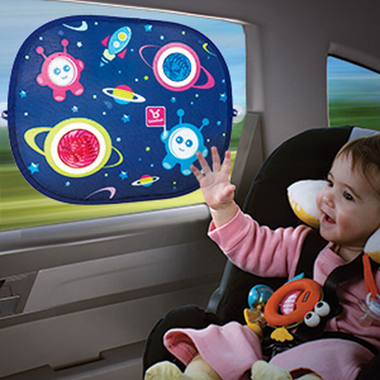 Benbat Car Sunshade Rounded With Suction Cups, blue space print suctioned to rear window as baby smiles and reaches.
