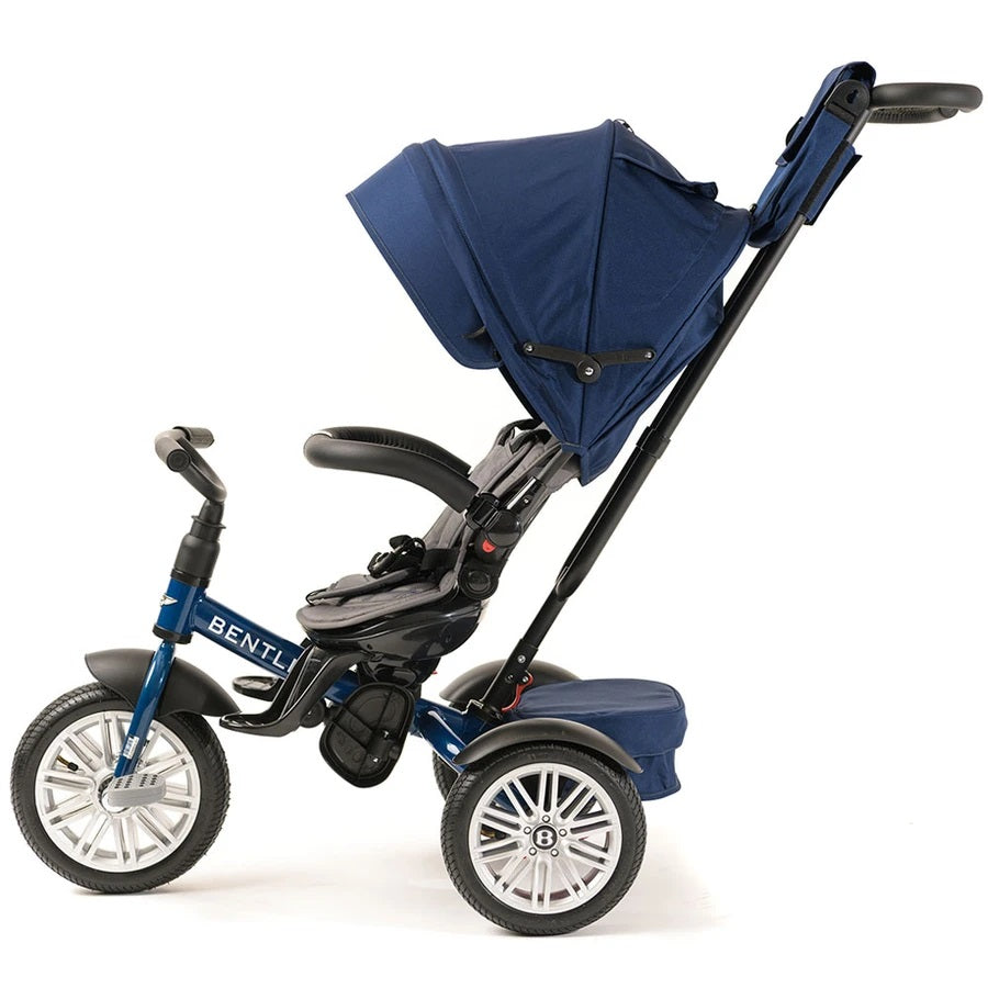 Bentley Trike 6-In-1 V2 Sequin Blue with blue canopy and adjustable push handle, guiding a toddler.