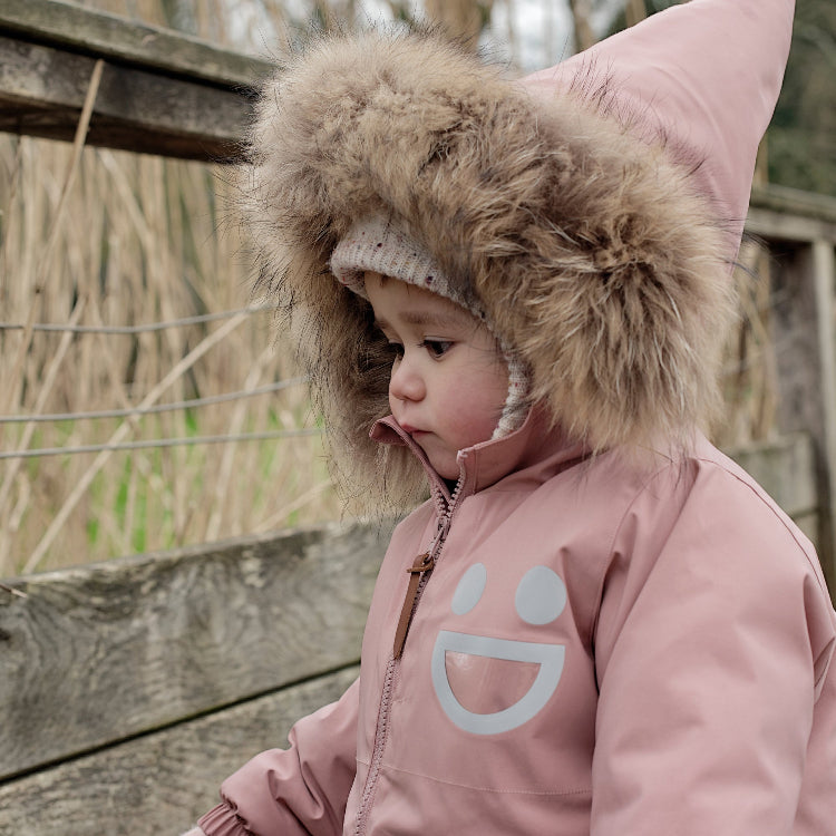 Boxbo Wistiti fleece-lined waterproof snowproof fur jacket in dusty rose pink, toddler with fur-trim hood outdoors.