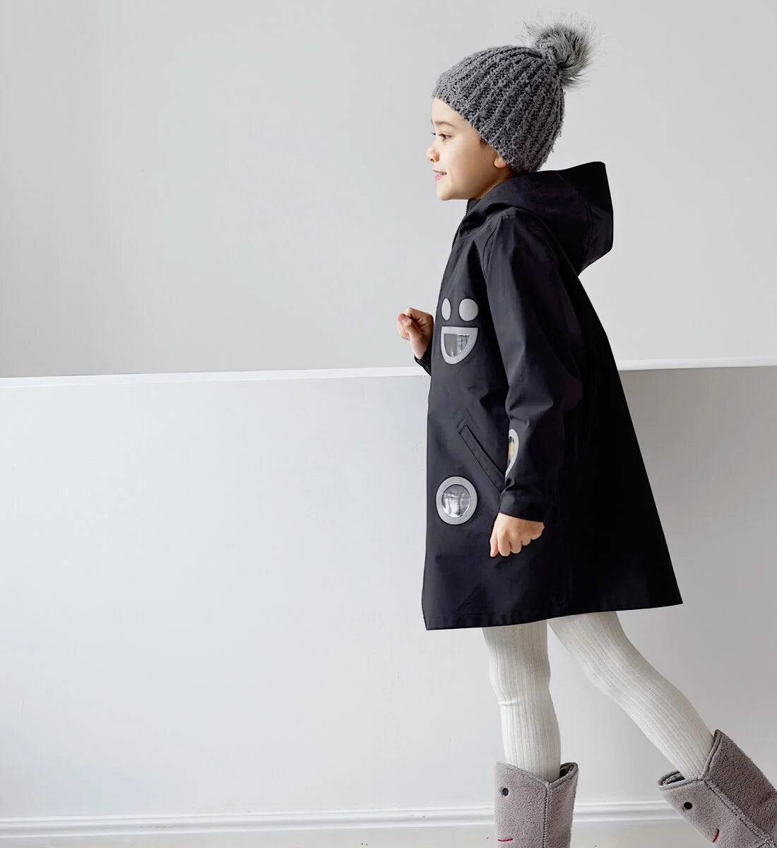 Child wearing the black BOXBO Wistiti rain jacket, side view