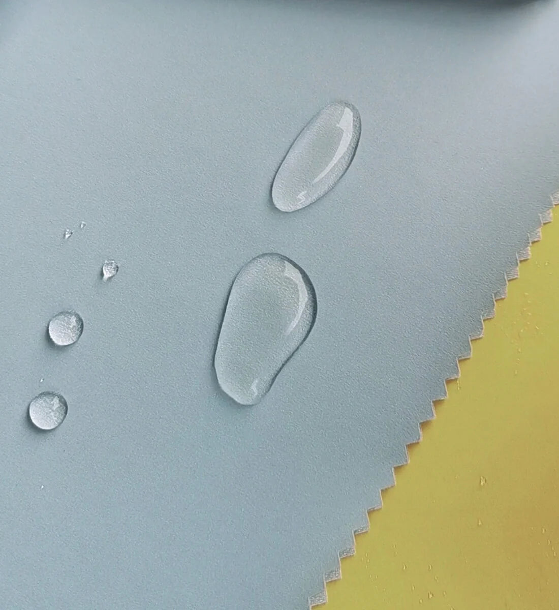 Water droplets on the blue BOXBO Wistiti rain jacket fabric