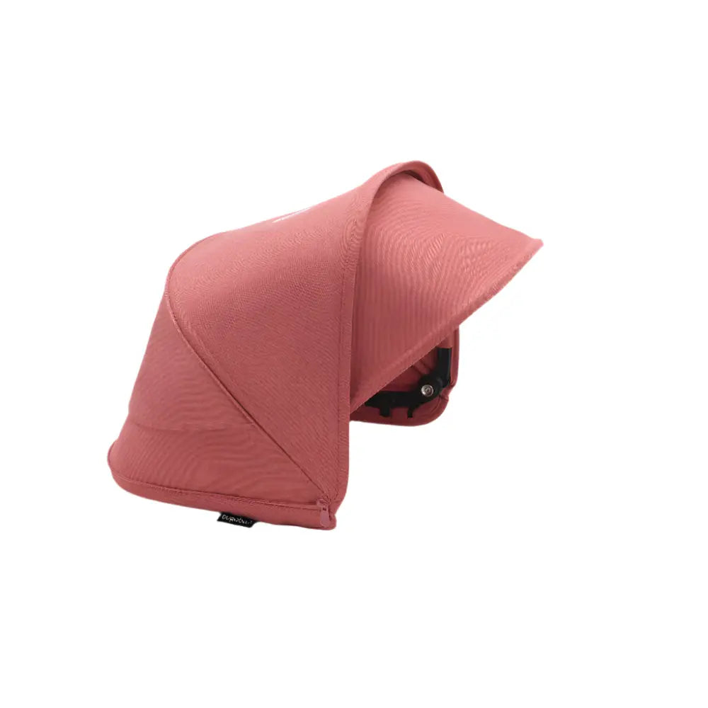 BUGABOO Dragonfly Sun Canopy in dusty pink fabric shown attached to a stroller, shielding sunlight.