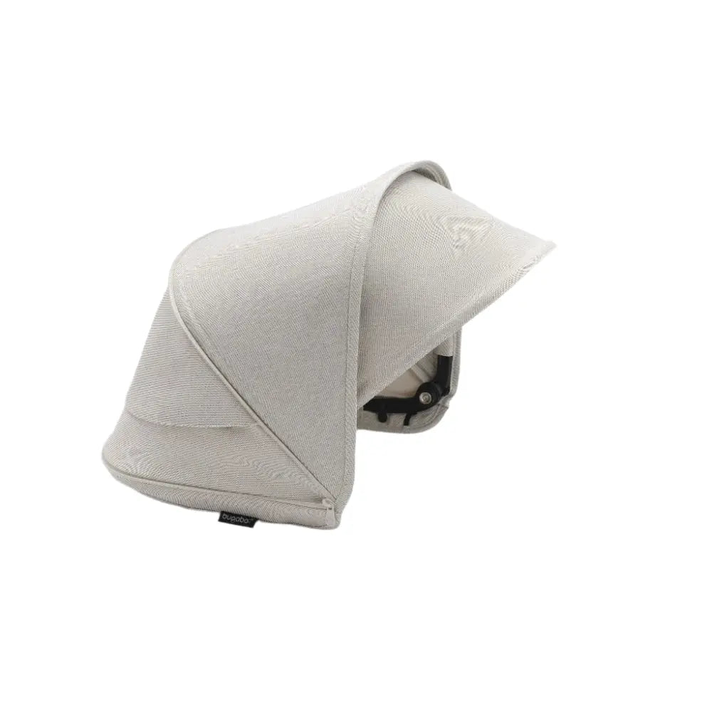 Bugaboo Dragonfly Sun Canopy in beige fabric draped over a stroller to shield a child from sun.