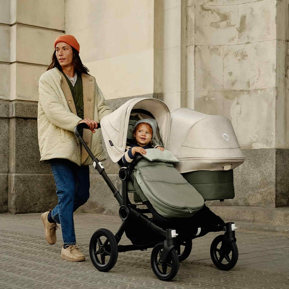 Bugaboo Footmuff in Olive Green on stroller with baby seated inside.