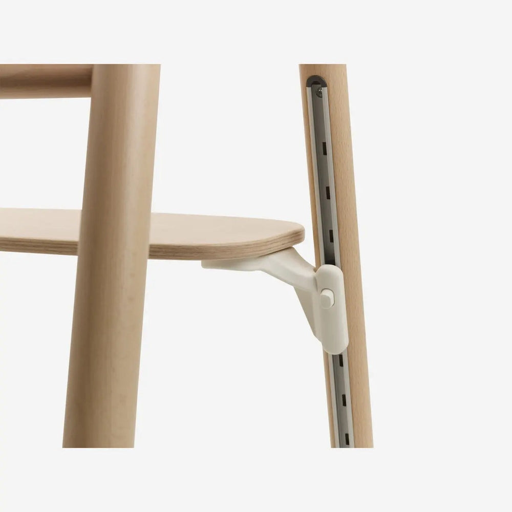 Bugaboo Giraffe Complete High Chair Set in light wood with white height-adjust clamp gripping the rail to show adjustability.