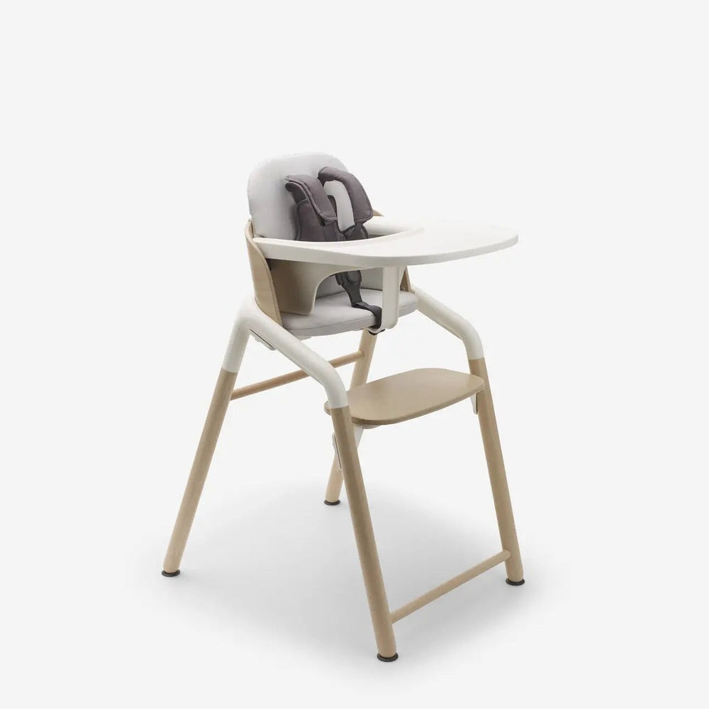 Bugaboo Giraffe Complete High Chair Set with beige frame, gray cushion, white tray attached for feeding.