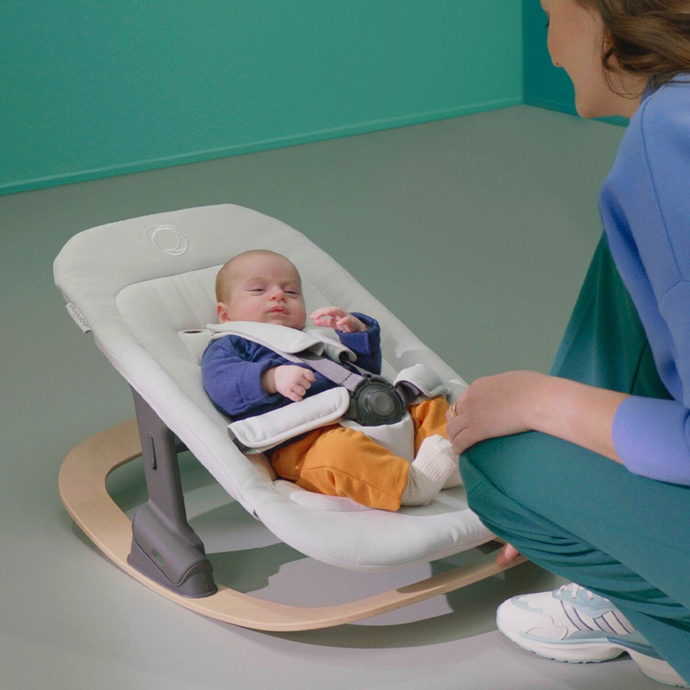 Bugaboo Giraffe Rocker Frame in neutral wood with baby seated in white rocker seat