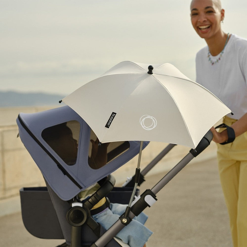 Bugaboo Parasol+ in white attached to stroller providing sun shade for baby during outdoor walk