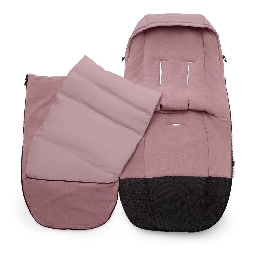 Bugaboo Performance Winter Footmuff, pink with black base, shown attached to a stroller to keep baby warm.