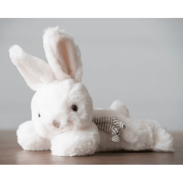 Bukowski Bears Bunny Coco stuffed animal in white plush with pink ears, lounging on a table with striped bow.