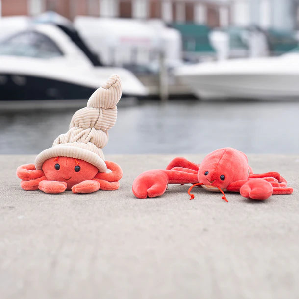 Bukowski Bears Hermit The Crab stuffed toy, coral crab duo on a dock by moored boats.