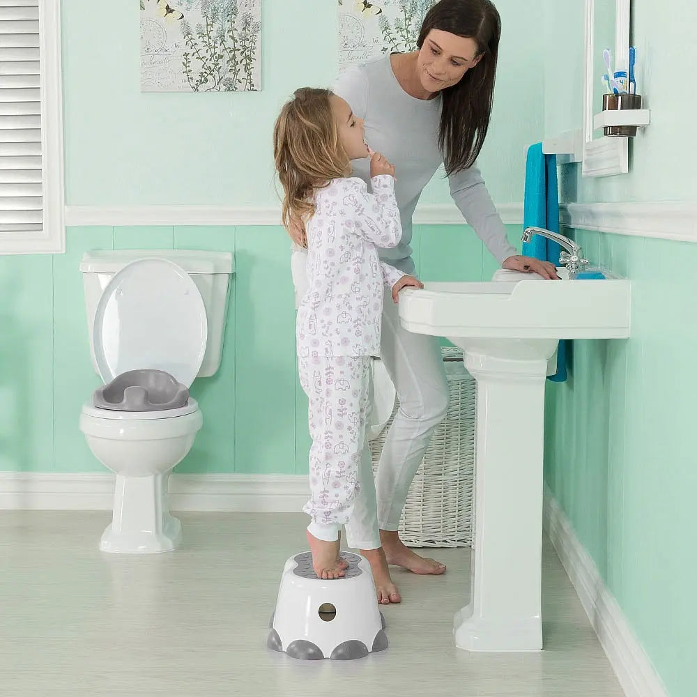 Bumbo Step Stool white with gray non-slip feet; toddler stands on stool at sink as mom helps.