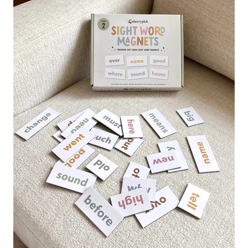 Cherrypick Sight Word Magnets in multicolor text on white tiles scattered on beige sofa with the box.