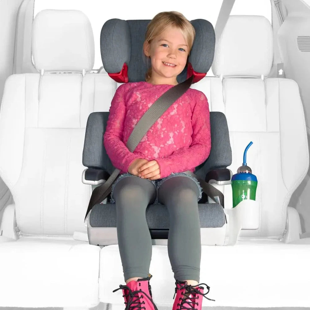 Clek Boost Seat Oobr high-back booster in gray; smiling child buckled with seat belt beside a cup.
