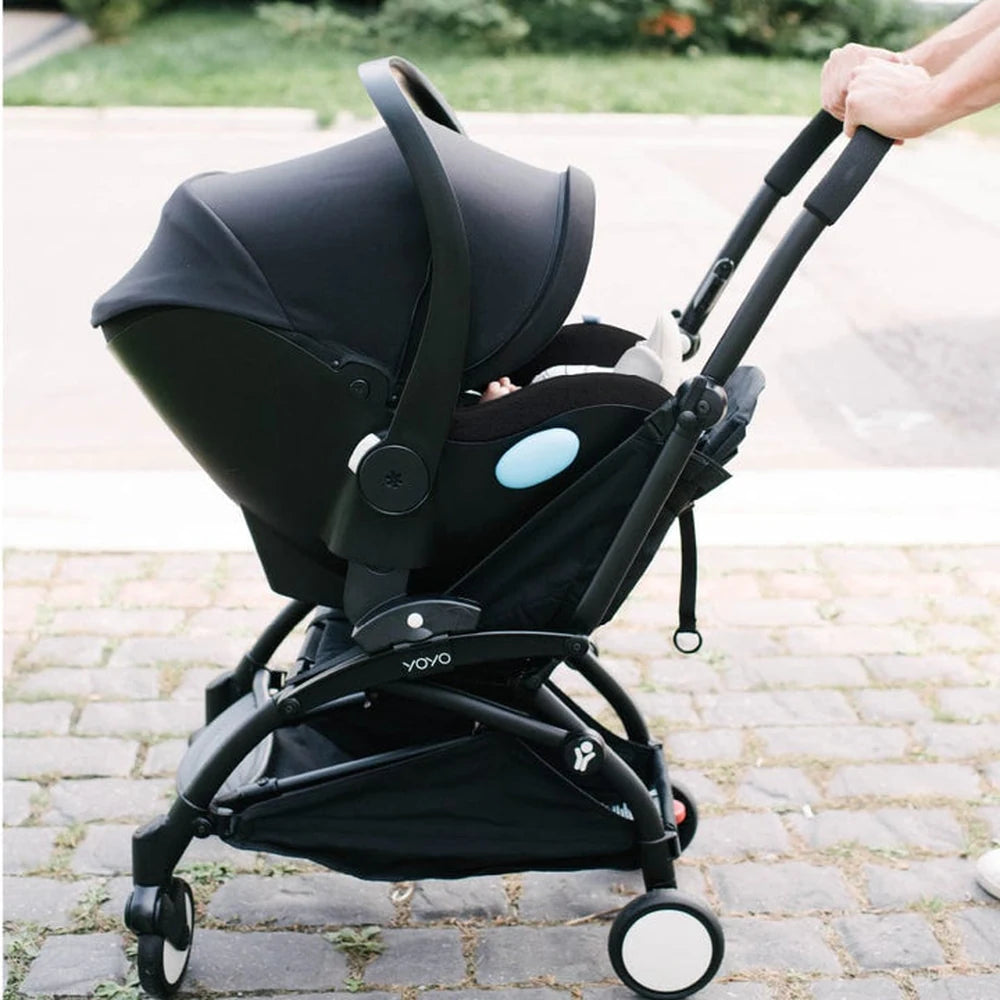 Clek Liingo Railroad infant car seat on a black stroller frame with blue accent.