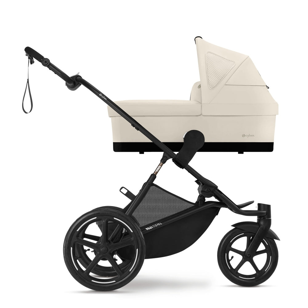 Close-up of the Cybex Avi Spin All Terrain Stroller with beige bassinet, black frame, showing large wheels for rugged terrain.