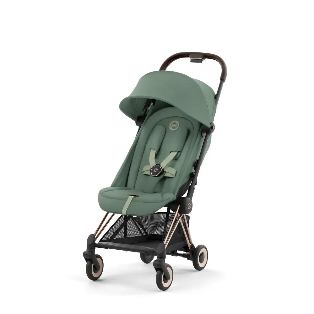 Close-up of the Cybex Coya Rose Gold Frame Stroller in sage-green fabric with sun canopy and four-wheel rose-gold frame.