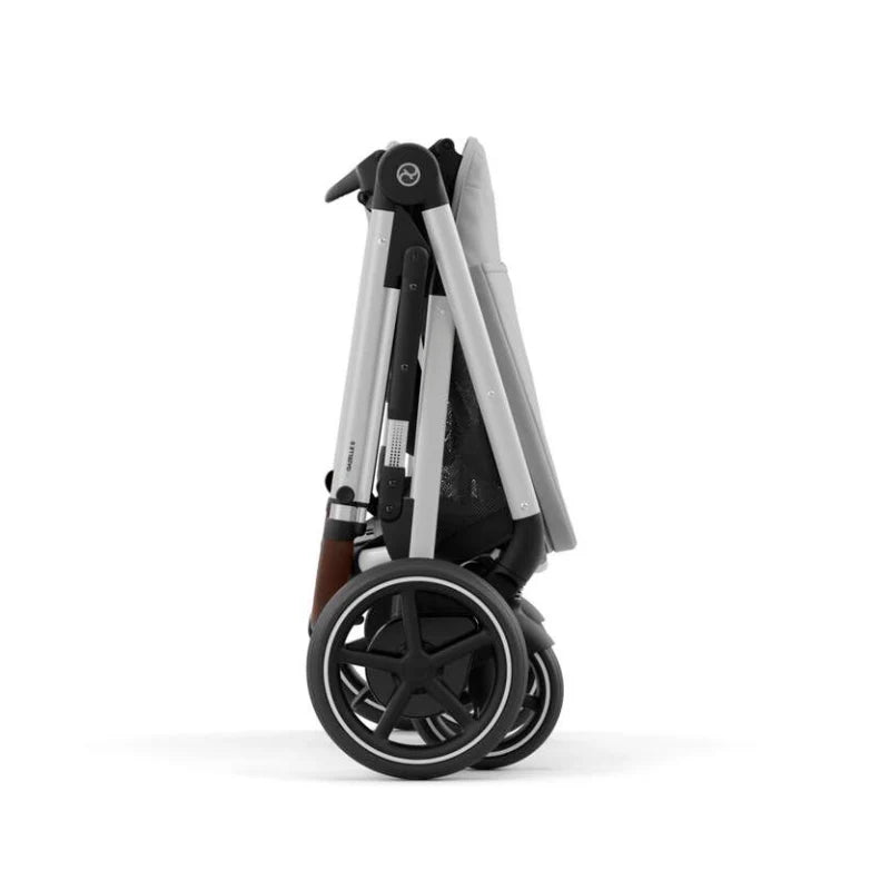 Close-up of the Cybex E-Gazelle S Stroller folded with large wheels visible, silver frame, black accents.