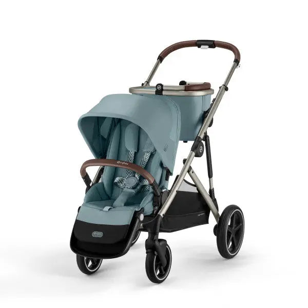 Close-up of the Cybex Gazelle S V2 Stroller in teal with brown leather handles, extended canopy, and four wheels.