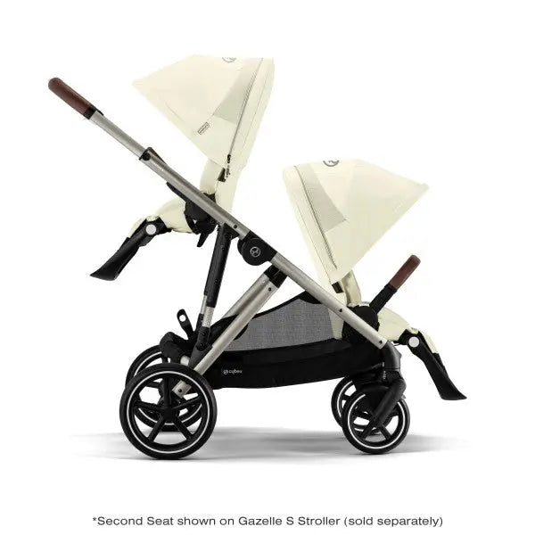 Close-up of the Cybex Gazelle S V2 Toddle Seat with cream seats and brown handles in a twin-seat setup.