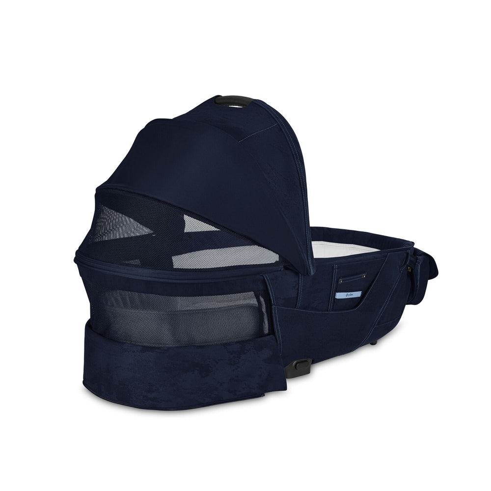 Close-up of the Cybex Platinum Priam Carry Cot Limited Edition - Rebellious Luxury Denim Blue denim blue carry cot for cybex priam stroller with navy hood and mesh side panels.