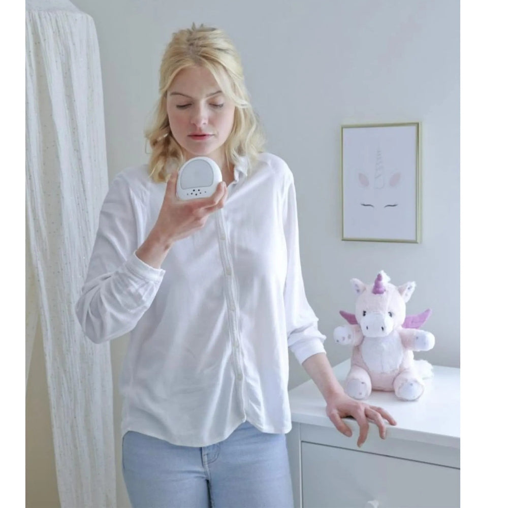 Cloud B Lily the Unicorn Love Light plush on a white dresser with pink accents and a framed unicorn print