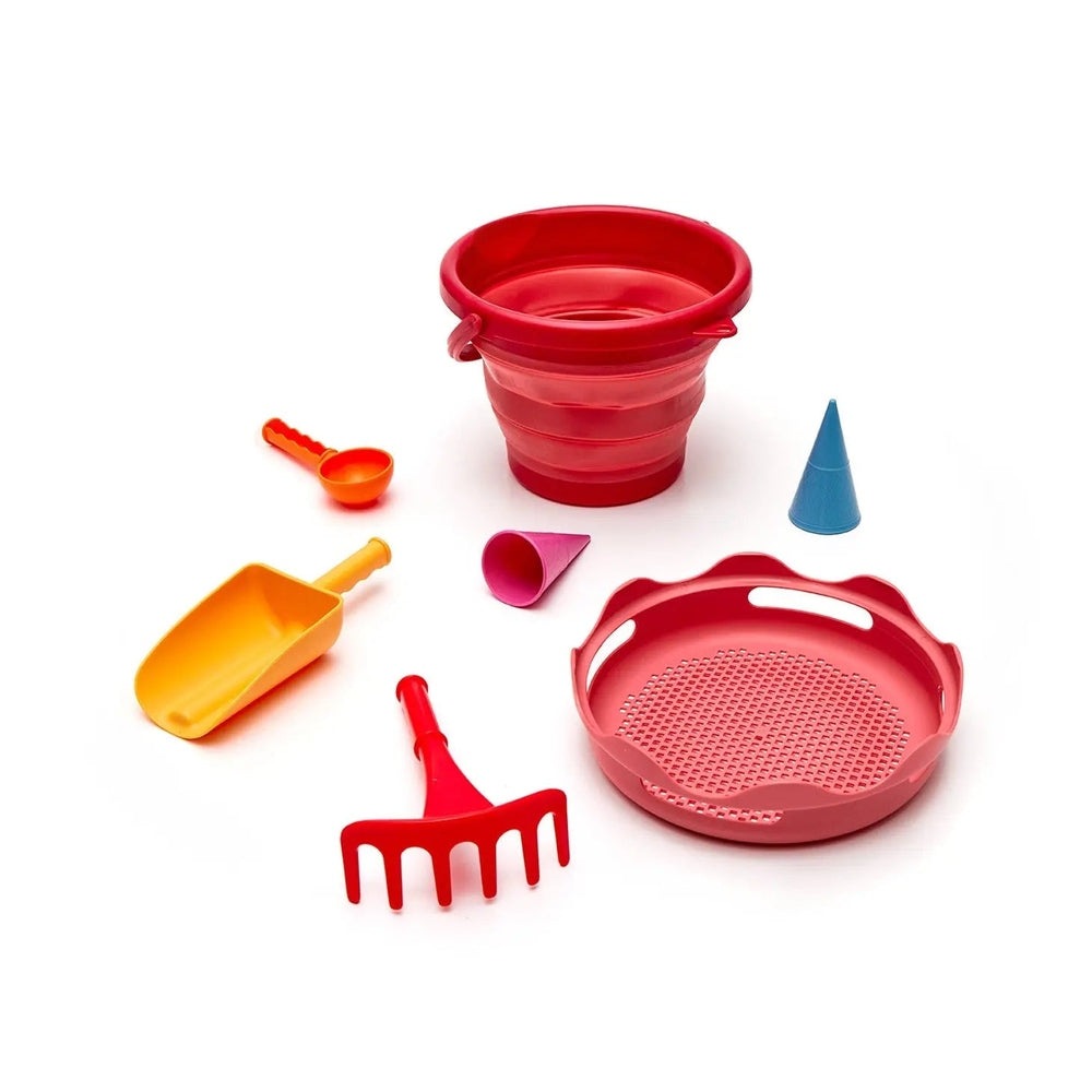 Compactoys 7-in-1 Sand Toy Set for toddlers; red bucket with assorted colorful tools laid out for play.
