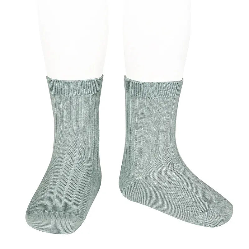Condor Basic Rib Short Socks Dry Green worn on baby feet, showcasing rib-knit texture and snug fit.