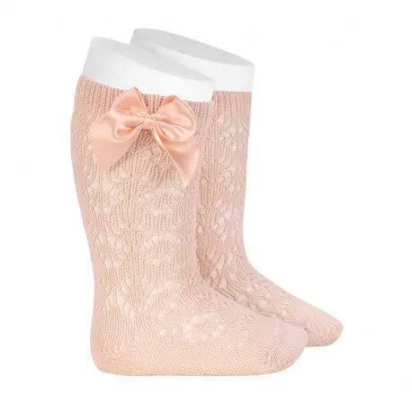 Condor Perle Geometric Openwork Knee High Socks With Bow Nude; baby lace socks with peach bow shown on a white display leg