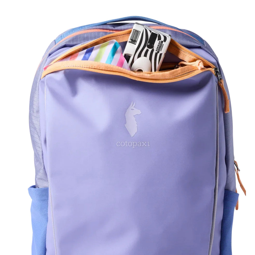 Cotopaxi Allpa 18L Daypack in Lavender with peach zipper, front logo, top pocket open showing items.
