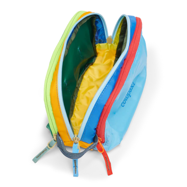 Cotopaxi Nido Accessory Bag in light blue with orange and red zippers, lime trim, open to yellow interior.