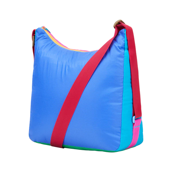 Cotopaxi Taal Convertible Tote in Blue with red crossbody strap and pink zipper accents, side view