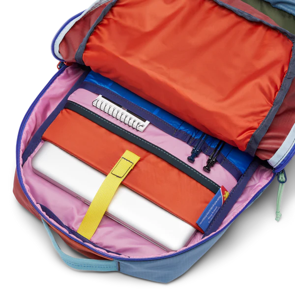 Cotopaxi Tasra 16L Backpack in pink interior with orange pocket, blue zippers, and yellow laptop strap.