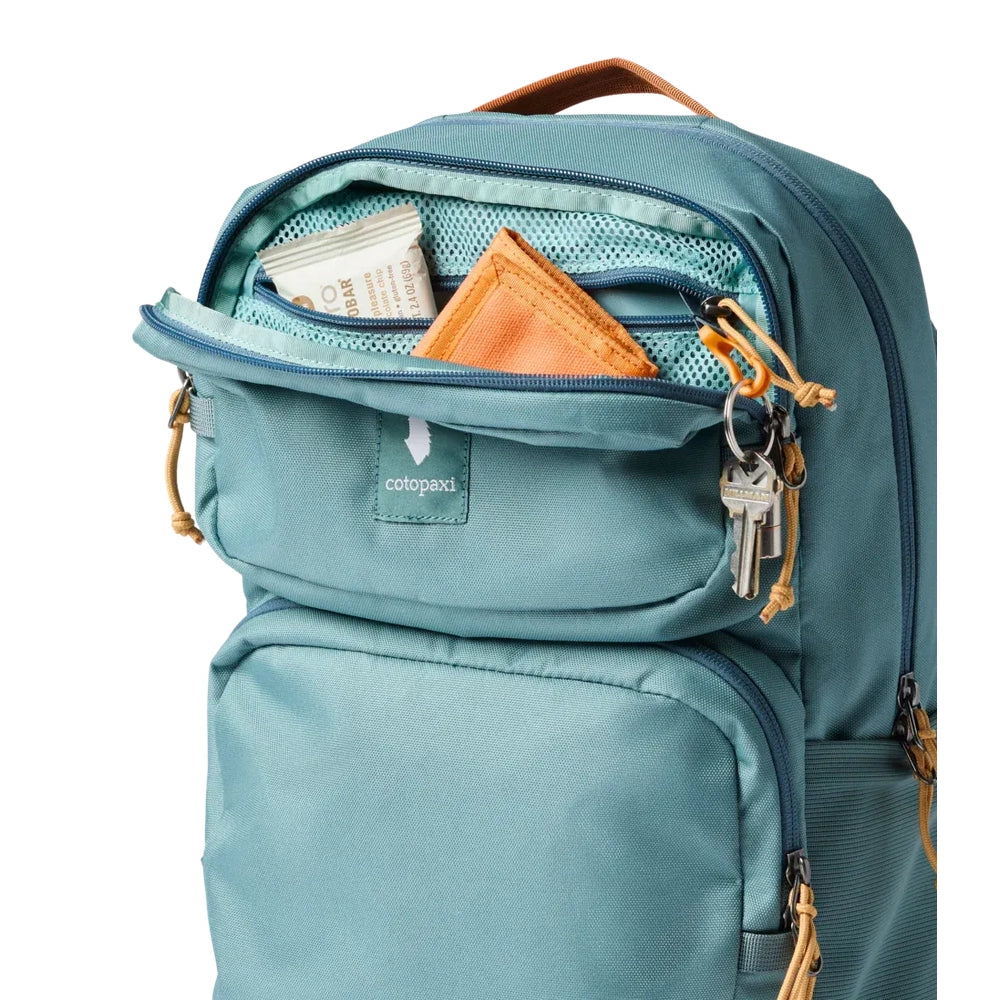 Cotopaxi Tasra 16L Daypack in Teal with front pocket open, teal mesh interior and orange zipper pulls.