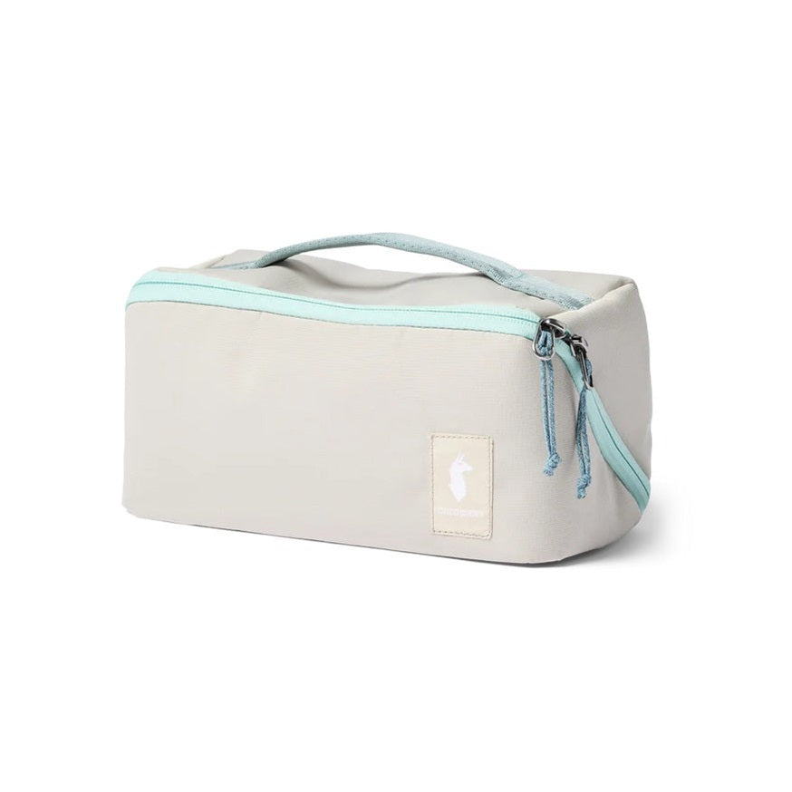 Cotopaxi Travel Toiletry Kit in Beige with turquoise zipper and top handle