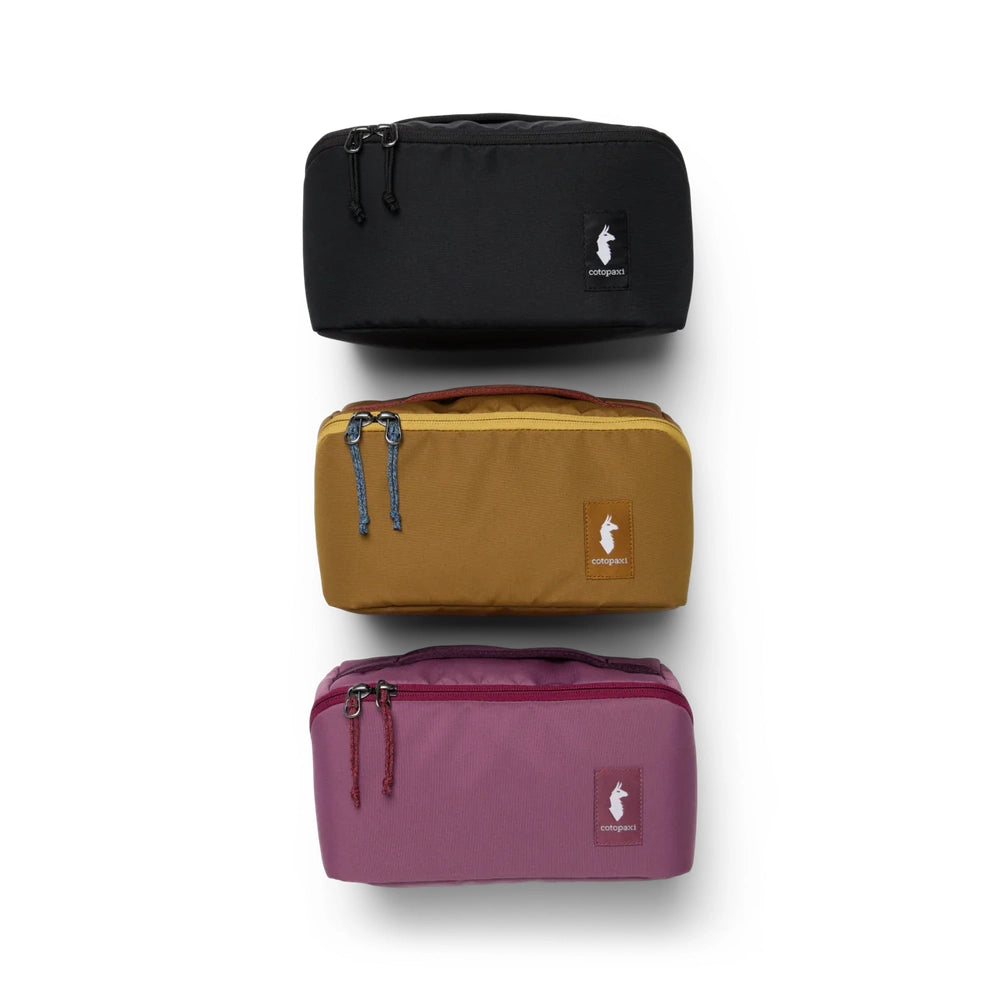 Cotopaxi Travel Toiletry Kit in Black, Mustard, and Plum, stacked vertically.
