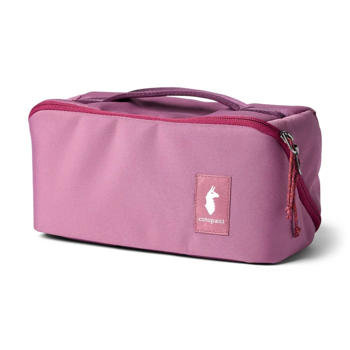 Cotopaxi Travel Toiletry Kit in Pink with red zipper and top handle.