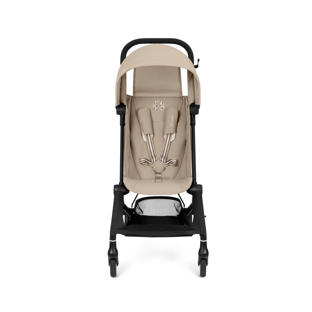 Lifestyle image of the Cybex Agis Lightweight Travel Stroller beige cybex agis travel stroller with black frame, beige canopy, and 5-point harness.