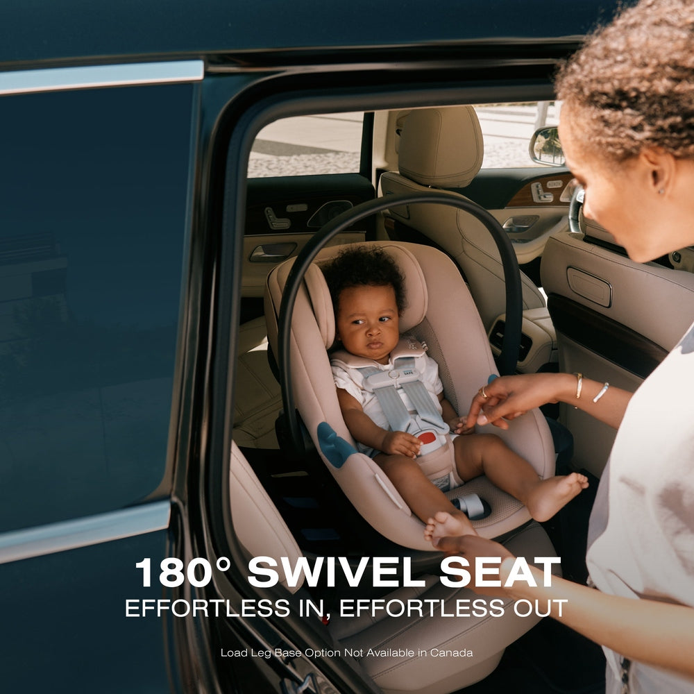 Close-up of the Cybex Aton G Swivel Sensorsafe Infant Car Seat beige fabric infant car seat in car, 180 swivel feature, harness visible as caregiver adjusts.