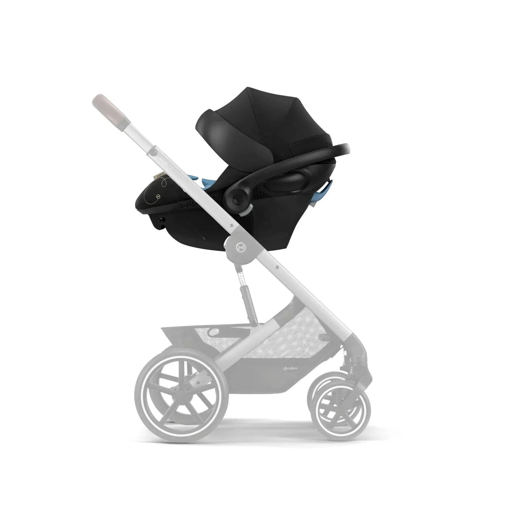 Lifestyle image of the Cybex Aton G Swivel Sensorsafe Infant Car Seat secured on a silver stroller frame with black upholstery.