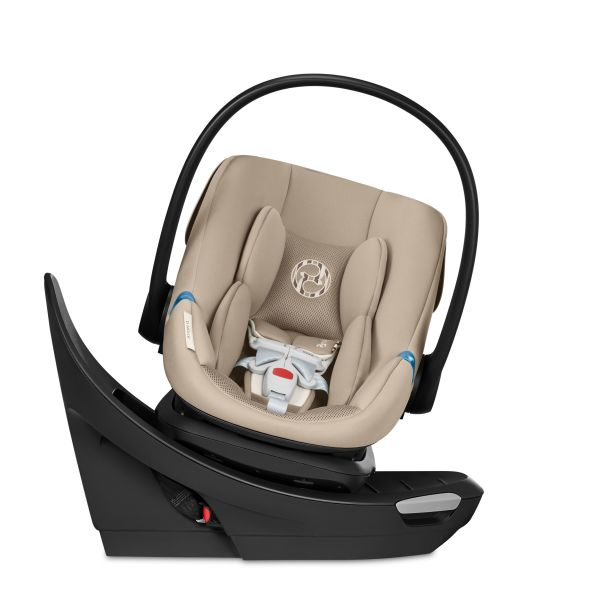 Close-up of the Cybex Aton G Swivel Sensorsafe Infant Car Seat beige fabric infant car seat on a black swivel base with a curved carrying handle and sensorsafe badge.