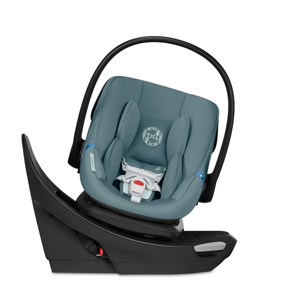 Close-up of the Cybex Aton G Swivel Sensorsafe Infant Car Seat teal fabric infant car seat with mesh back panel, curved carry handle, mounted on black base.