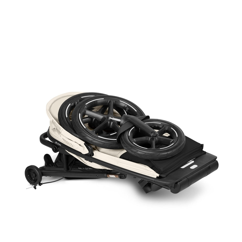 Close-up of the Cybex Avi Spin All Terrain Stroller folded compact with visible wheels in black and cream.