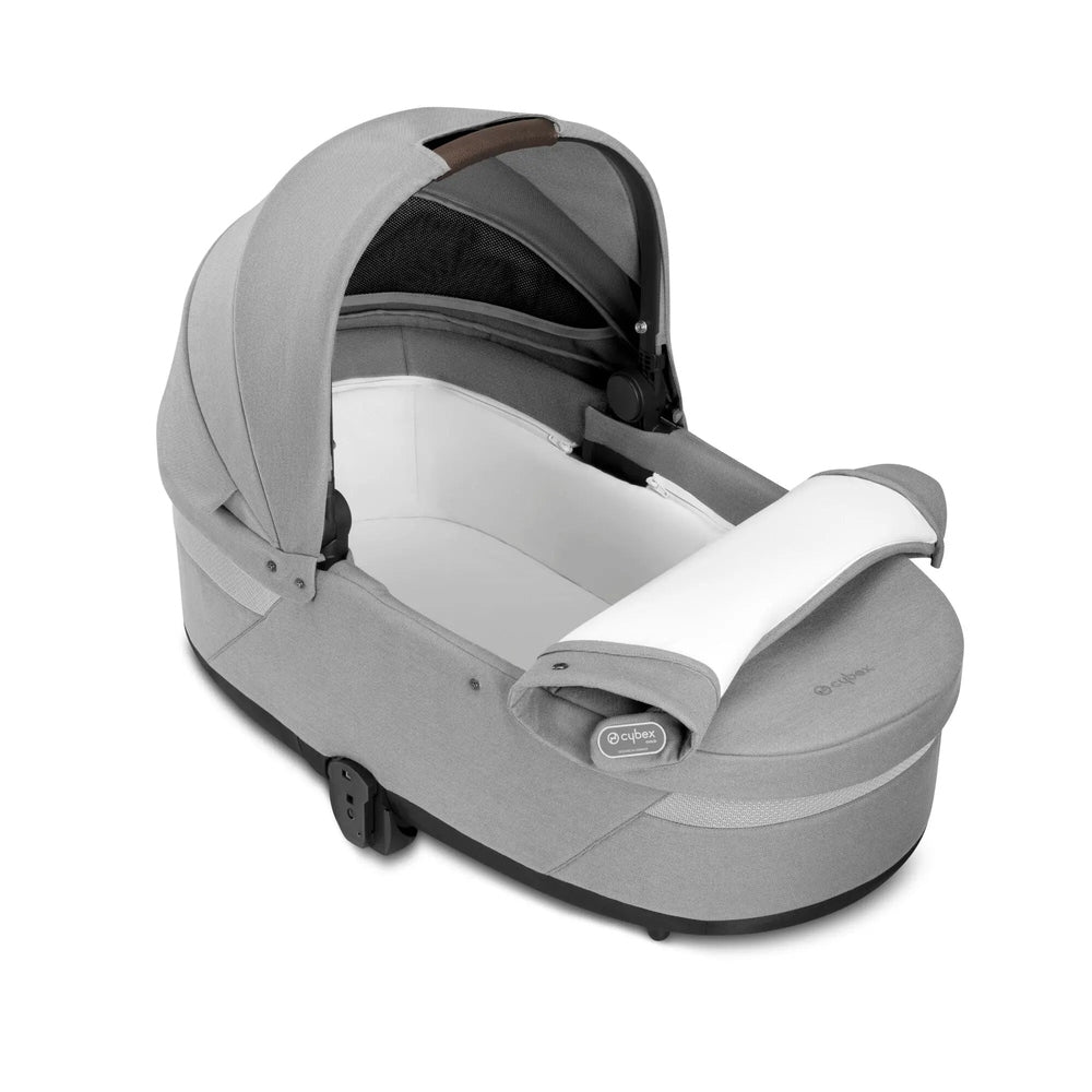 Studio detail image of the Cybex Balios S Lux Cot in light grey with the apron opened to reveal the interior.