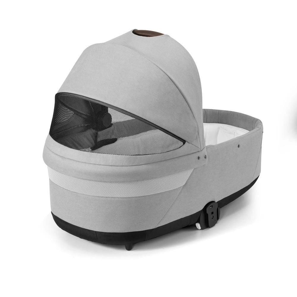 Studio detail image of the Cybex Balios S Lux Cot in light grey, front three-quarter view with the front cover partly opened.