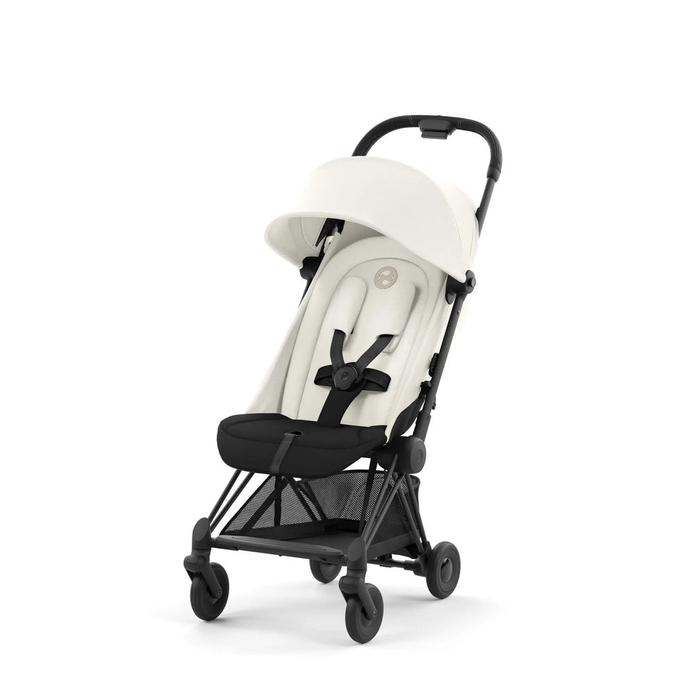 Close-up of the Cybex Coya Matt Black Frame Stroller with white seat and canopy, upright on four wheels.