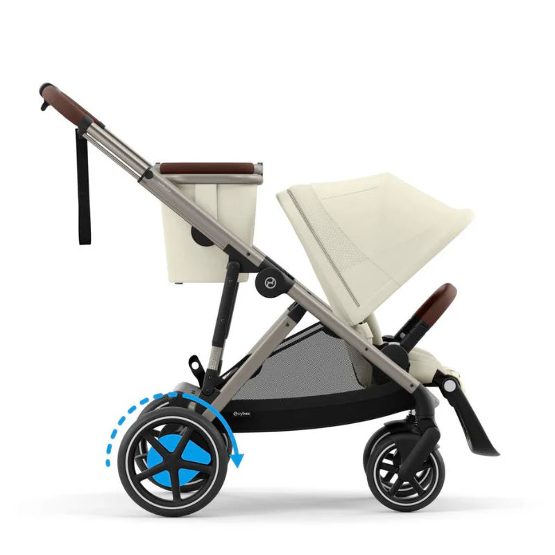 Close-up of the Cybex E-Gazelle S Stroller with beige seat, brown grips, and large rear wheels in motion, showing smooth steering.