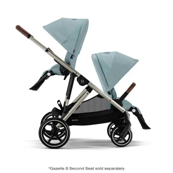 Close-up of the Cybex Gazelle S V2 Stroller teal fabric with aluminum frame and brown leatherette handles, double seats with canopies raised.