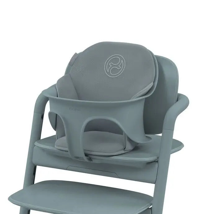 Close-up of the Cybex Lemo 2 Comfort Inlay booster insert in gray-blue fabric, securely attached to a high chair for added comfort.