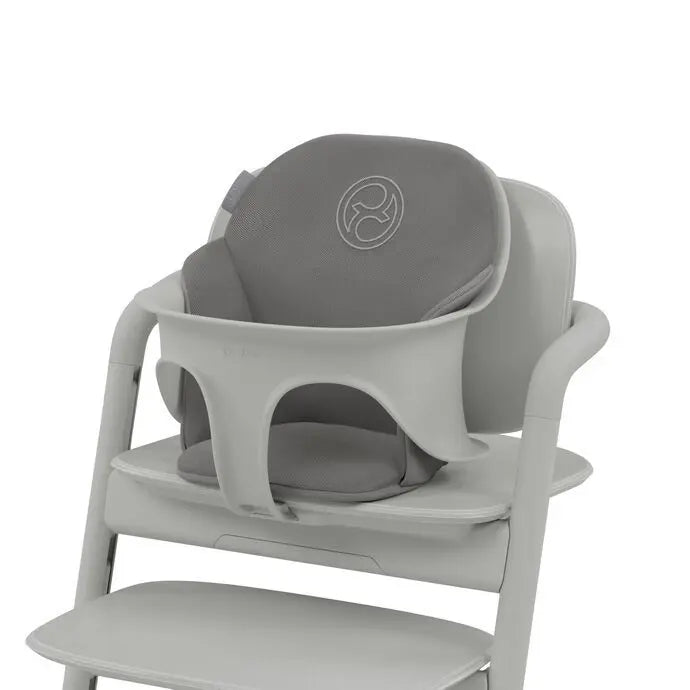 Lifestyle image of the Cybex Lemo 2 Comfort Inlay in gray attached to a high chair, providing soft baby cradle support.